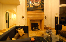 large marble gas-burning fireplace, two "Mies Van De Rough" designed black and caramel striped couches